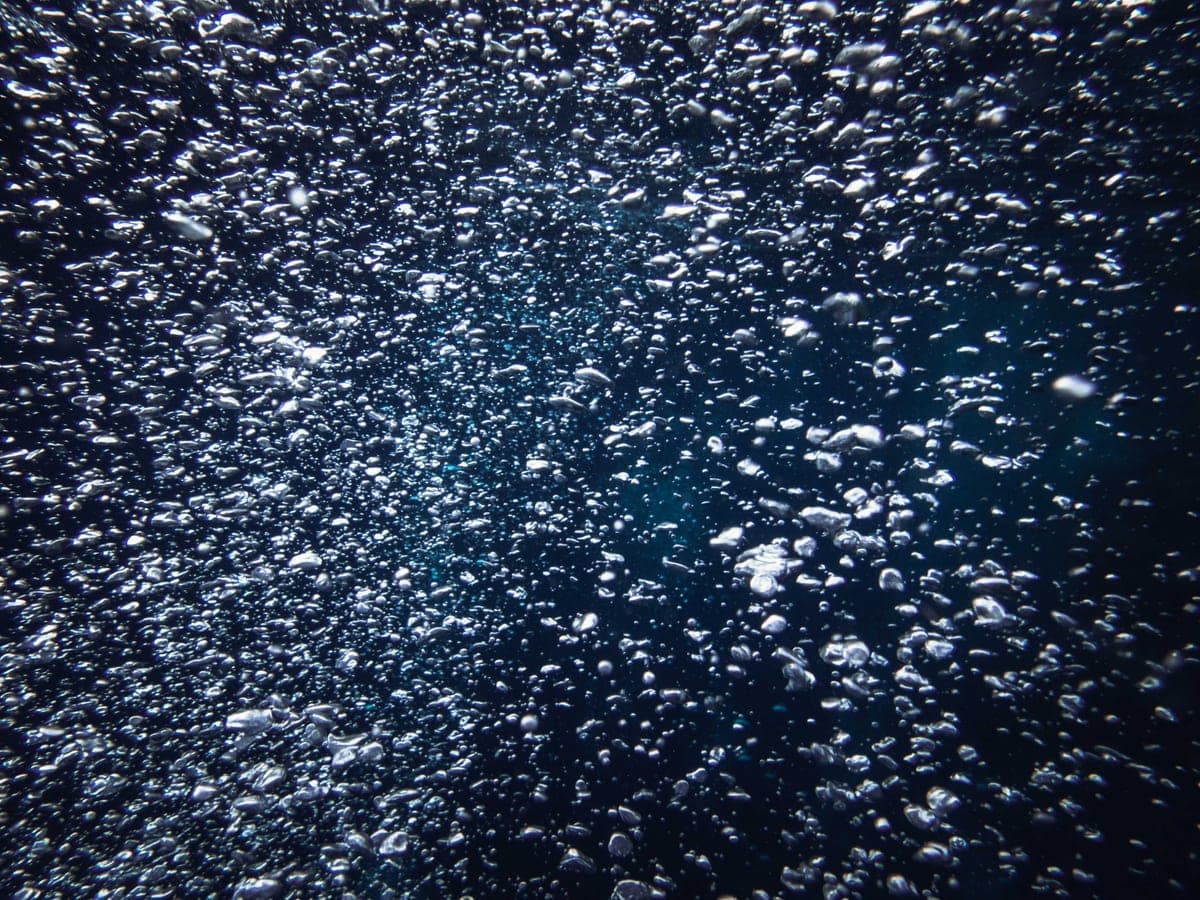 Bubbles rising through deep blue water